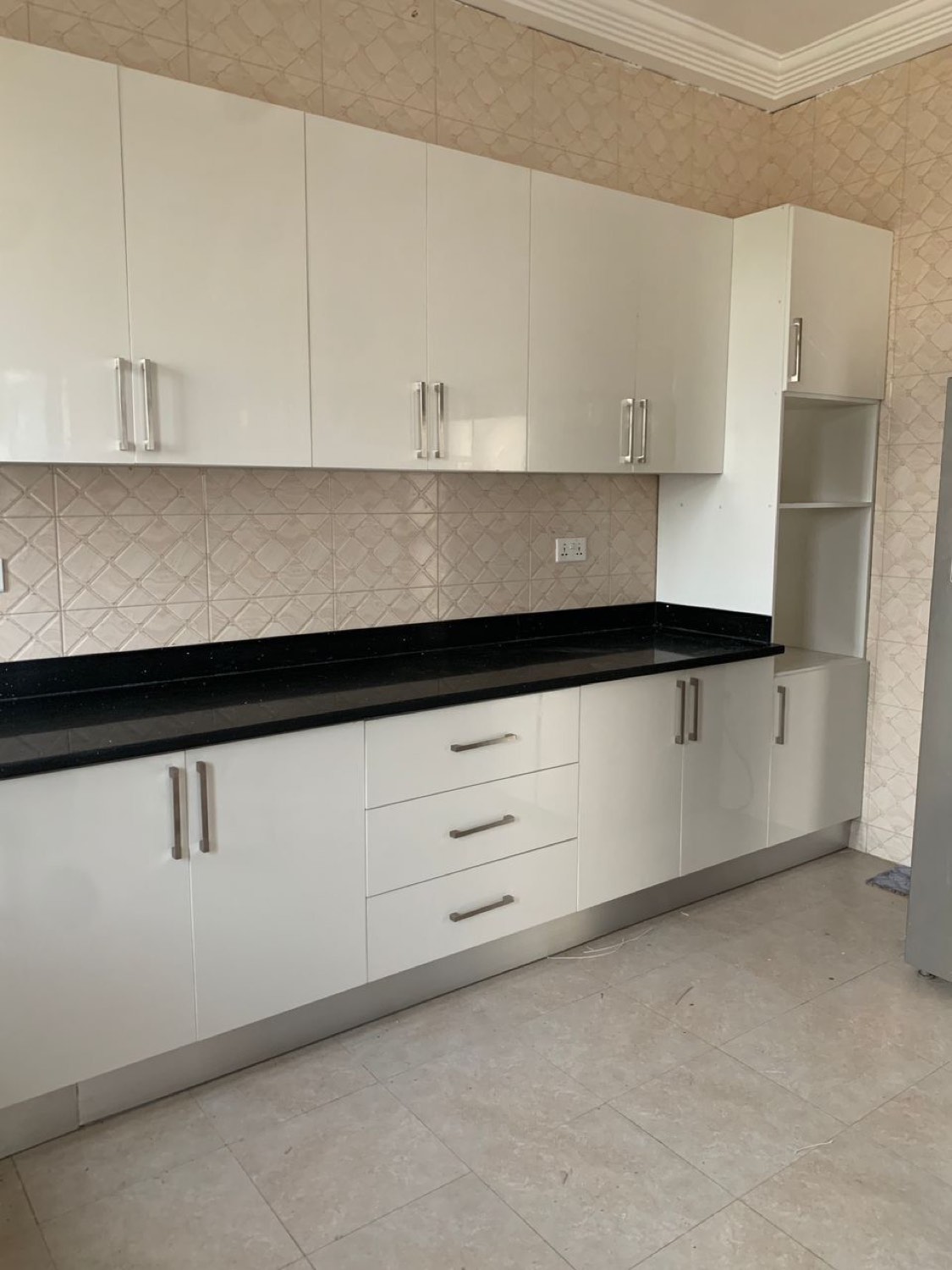 White gloss fitted kitchen with a stone worktop
